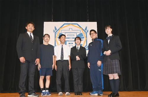 新しい制服、ジャージーを着用した現久慈東、久慈工の在校生。後方は新しい校章=7日、久慈市