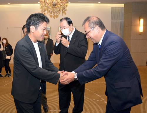 笑顔で握手を交わす宮下宗一郎知事(左)と自民の津島淳候補=19日、青森市