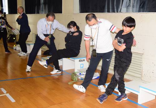 片足で立ち上がり、脚力を測る参加者