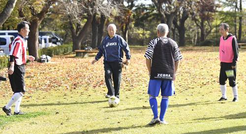 教え子たちとボールを蹴り合う石塚志朗さん(左から2人目)=11月上旬、八戸市南部山健康運動公園多目的広場