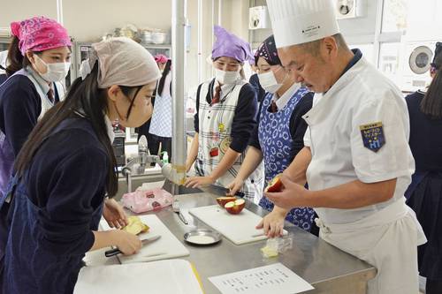 工藤謙さん(右)の指導を受けながら作業する生徒