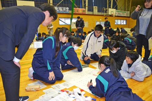 森本慎也さん(左)のアドバイスを受けながら、避難行動を書き込む生徒たち