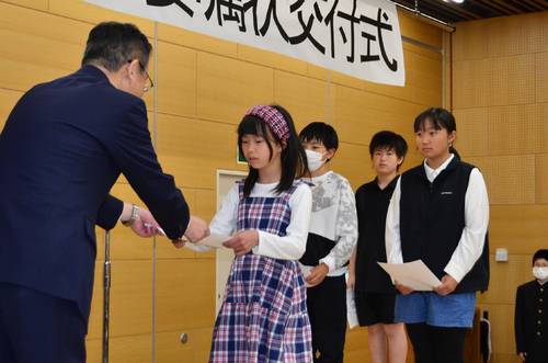 熊谷雄一市長(左)から委嘱状を受けるこどもモニターの児童生徒=24日、八戸市総合保健センター