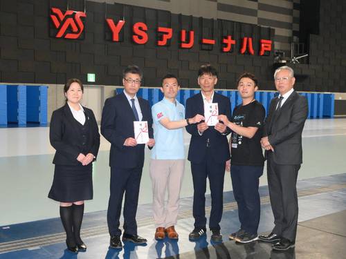小笠原修社長(右)から目録を受け取った、スピードスケートチームや青森県スケート連盟の関係者