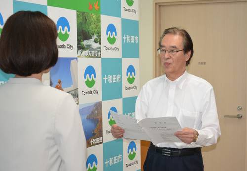 櫻田百合子市長(左)に世界遺産登録への推進体制の整備を求める中村秀行会長=11日、十和田市役所