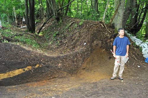確認された土塁、堀の前で説明する木山克彦准教授=8日、南部町