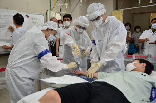 放射性物質が付着したけが人の処置について手順を確認した合同訓練=26日、八戸市の青森労災病院
