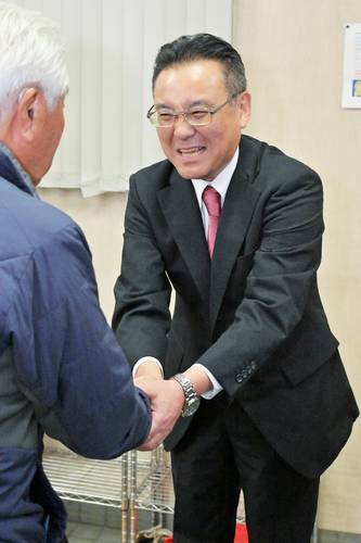 支持者と握手をする熊谷雄一さん=26日午後11時20分ごろ、八戸市江陽3丁目の選挙事務所