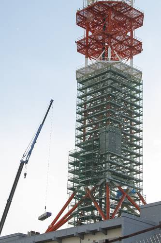 修復工事が完了したNTT青森八戸ビルの鉄塔。ビル屋上から資材が搬出されていた=26日午後1時半ごろ、八戸市