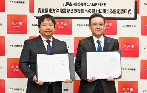 協定に調印した中島真代表(左)と熊谷雄一市長=27日、八戸市庁