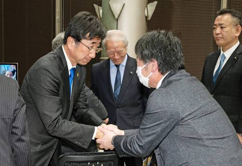 支援者と握手を交わす松尾和彦さん(左)=8日午後9時35分ごろ、八戸市