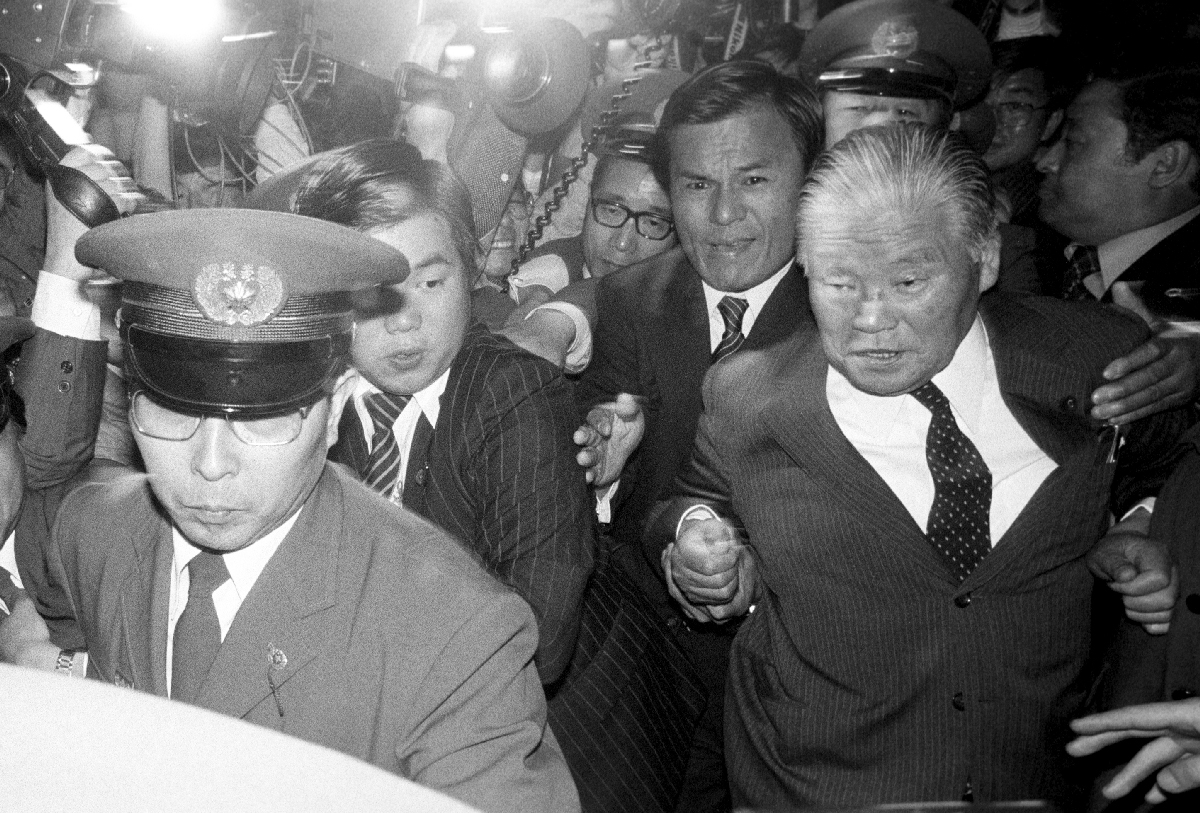 社会党の提出した内閣不信任案が、自民党反主流派の大量欠席で可決され、もみくちゃにされながら議場を出る大平正芳首相(右)=1980年55月16日