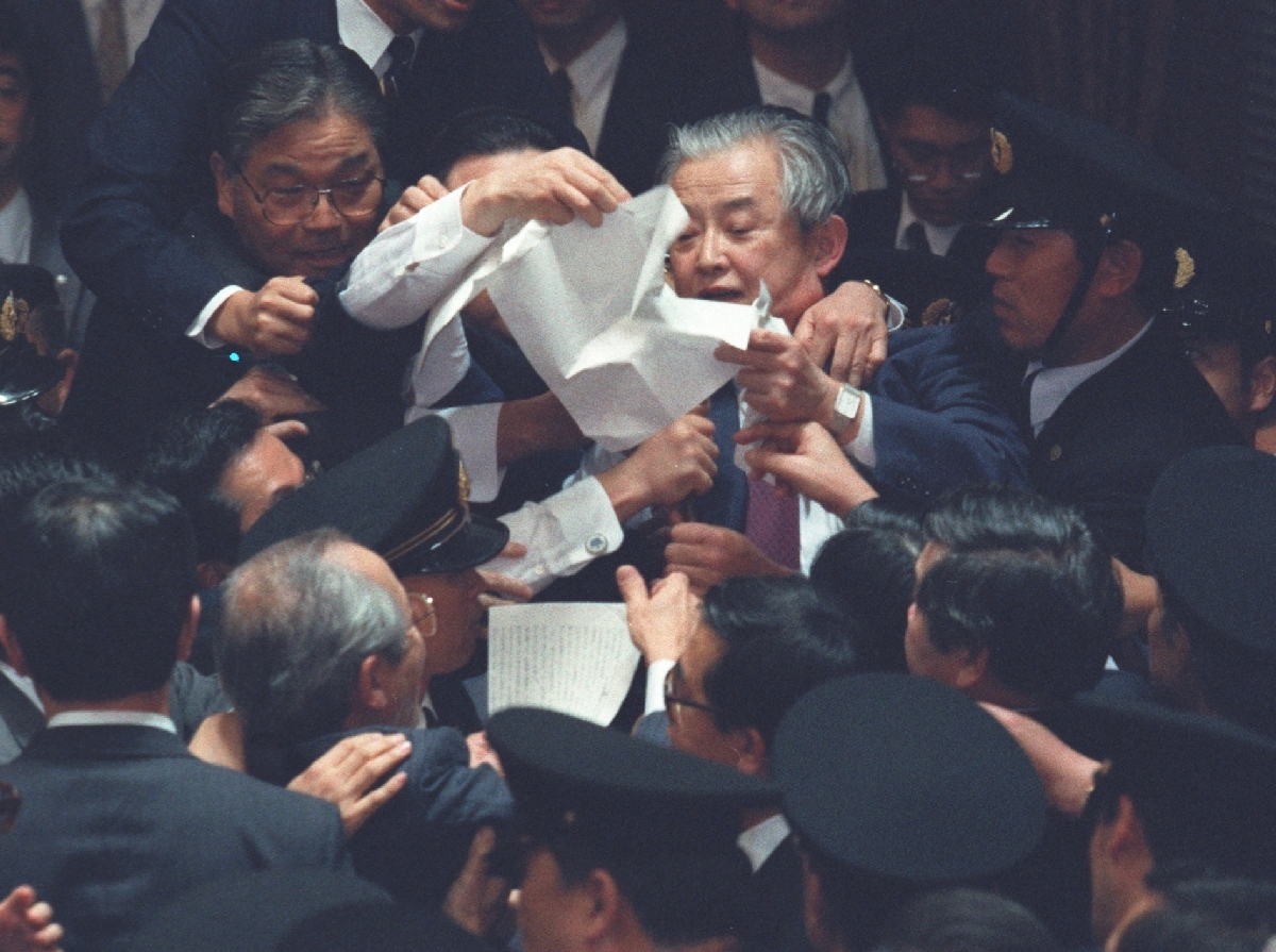 PKO協力法案の採決は与野党が入り乱れ、大混乱に。中央はもみくちゃにされながら文書を読み上げる林義郎委員長=1991年11月27日