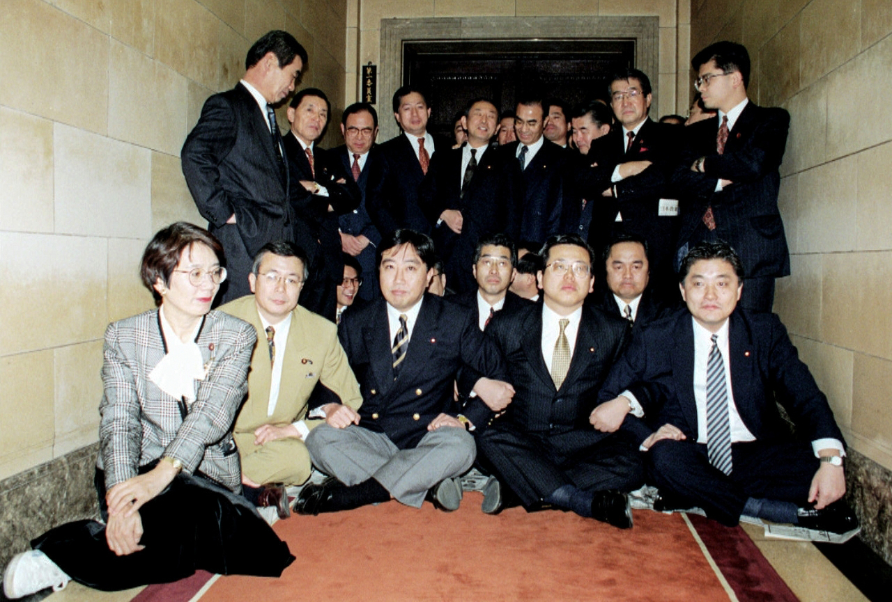衆院予算委員会が開かれる部屋の前に座り込み、封鎖する新進党の議員ら=1996年3月、国会