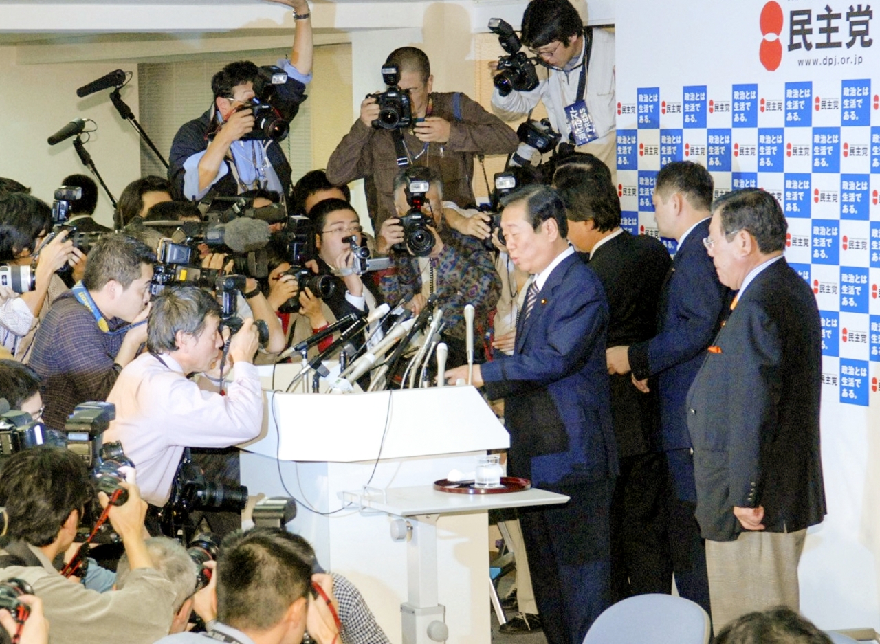 辞任表明の記者会見に臨む民主党の小沢一郎代表(中央)=2007年11月4日、東京・永田町の党本部