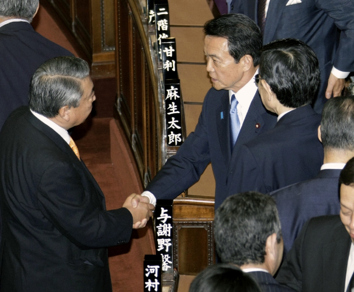 衆院が解散され、握手する麻生太郎首相(右)と、自民党の大島理森国会対策委員長=2009年7月21日、衆院本会議場