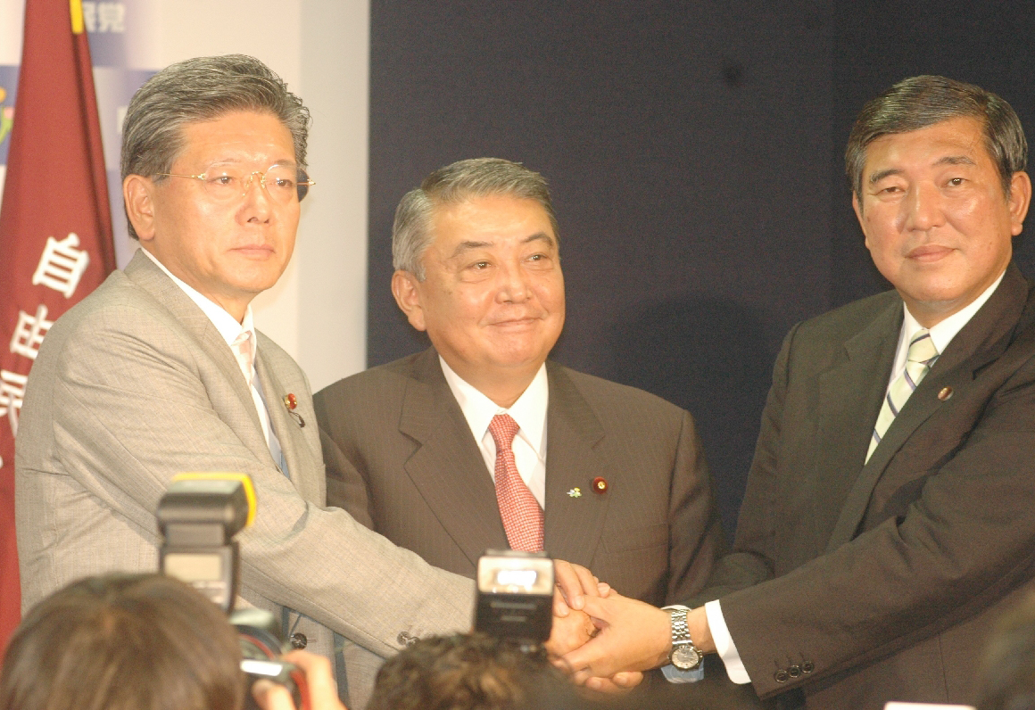 自民党役員の就任会見後、握手を交わす大島理森幹事長(中央)、石破茂政調会長(右)、田野瀬良太郎総務会長(左)=2009年9月29日、東京・永田町の党本部