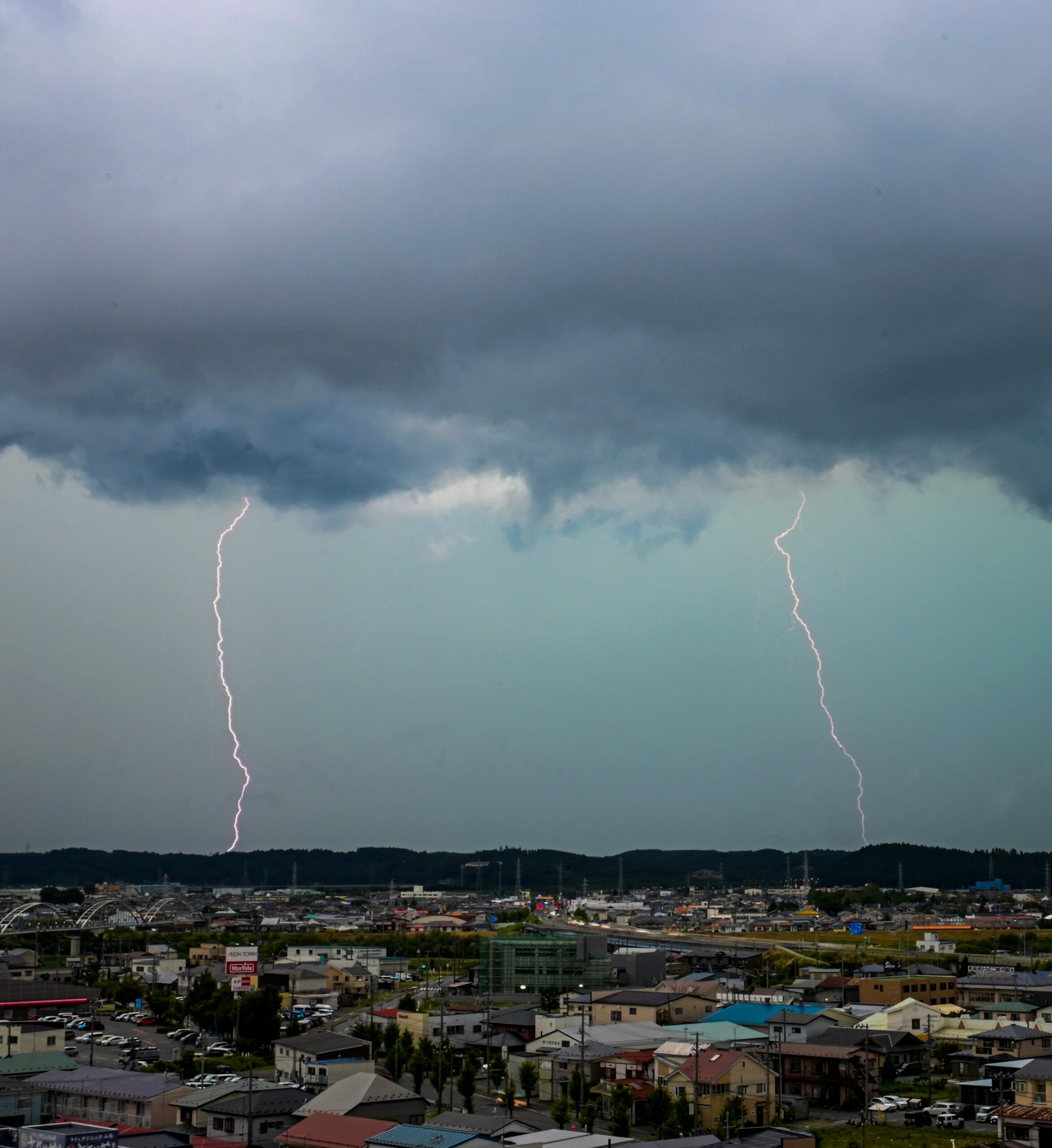 黒い雲から落ちる雷=12日午後3時15分ごろ、八戸市城下1丁目のデーリー東北新聞社屋上から北西方向を撮影