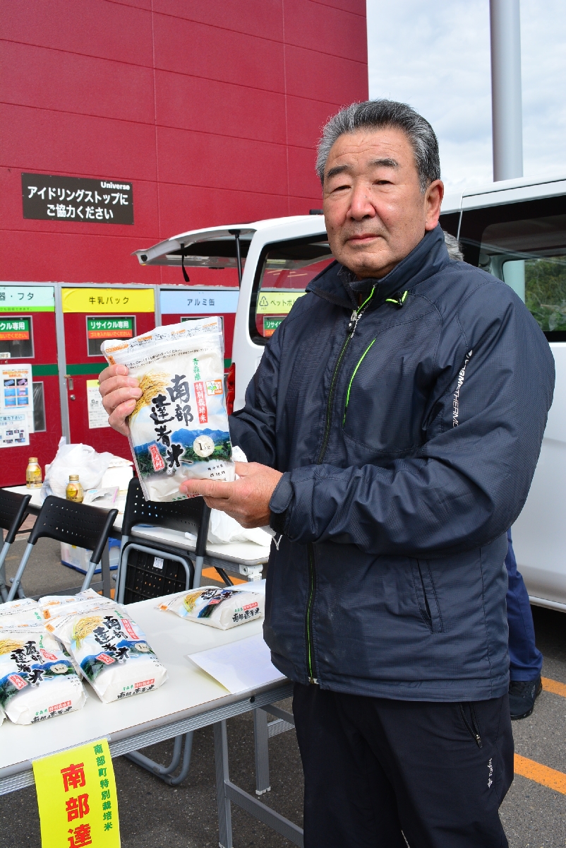 地域、全国の食卓へ届いた「はれわたり」。生産者の地元や農業への願いが込められている。新米をPRする山道金太郎さん。