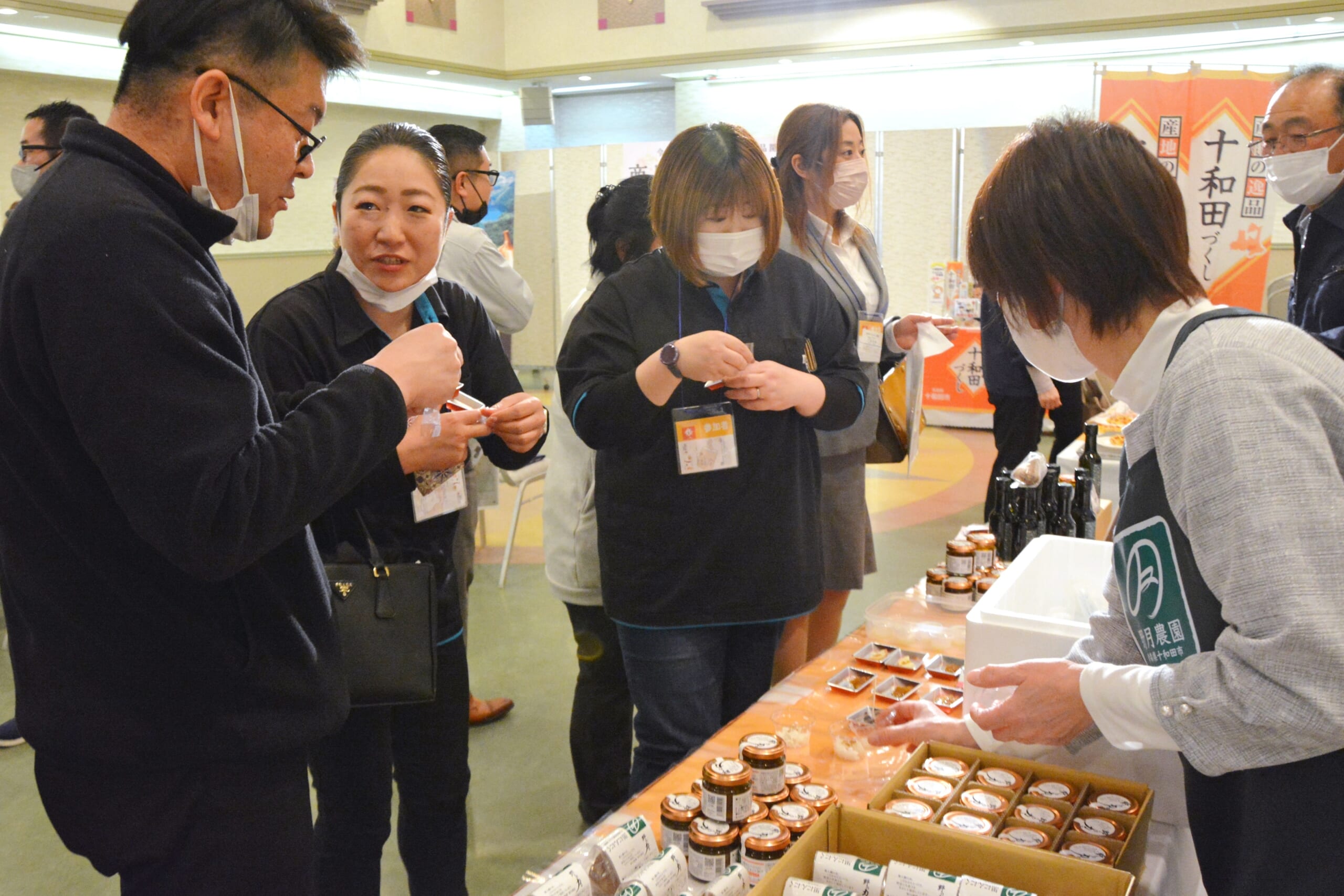 試食しながら商品の説明を聞く関係者