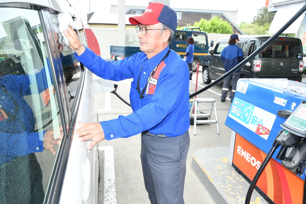 にぎわうガソリンスタンド。橋本喜代二さんは今も現場に出て汗を流す=5月、六ケ所村