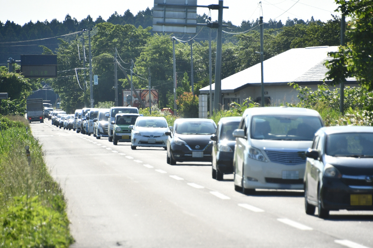 六ケ所村倉内地区の国道338号で、通勤時間帯に見られた長い車列。奥が三沢市方面=6月