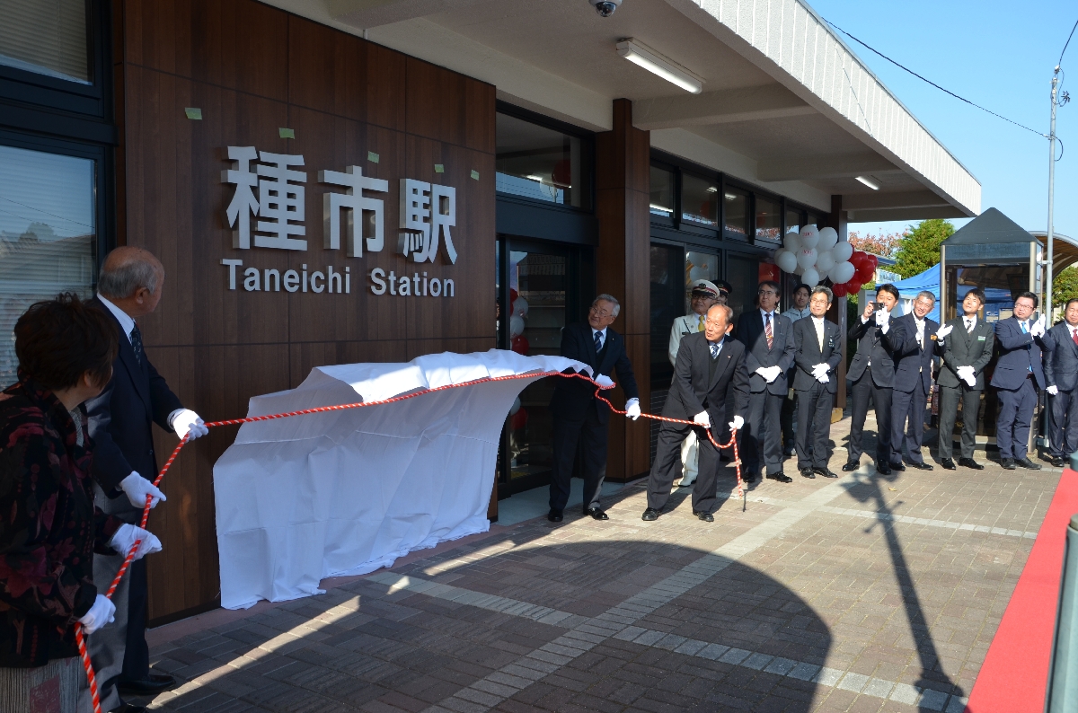 リニューアルした種市駅舎の除幕を行う関係者=9日、洋野町