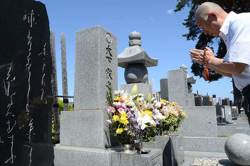 大下常吉が眠る廣澤寺の墓前で手を合わせる筆者=八戸市