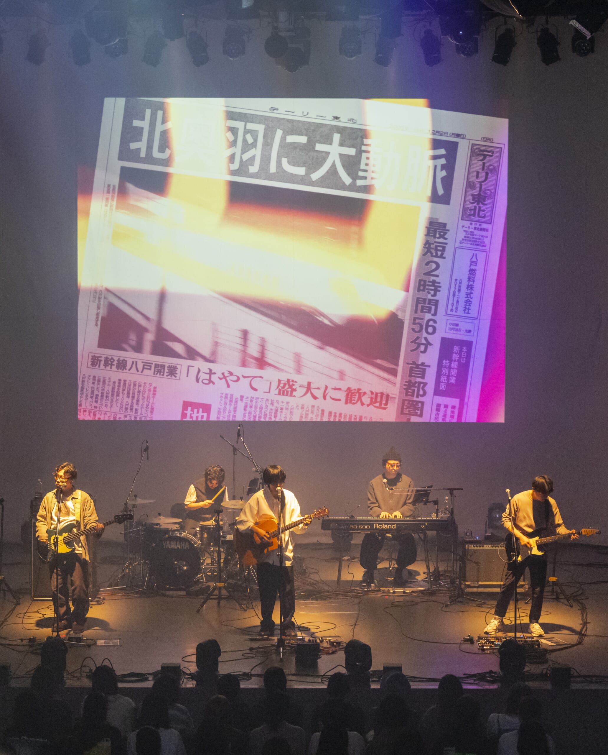 過去の紙面の映像を交えながら展開されたandropのライブ=29日、SG GROUP ホールはちのへ(市公民館)